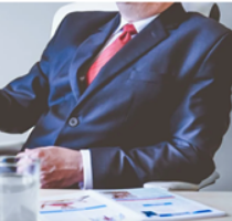 Picture of a businessman seated by an office table
